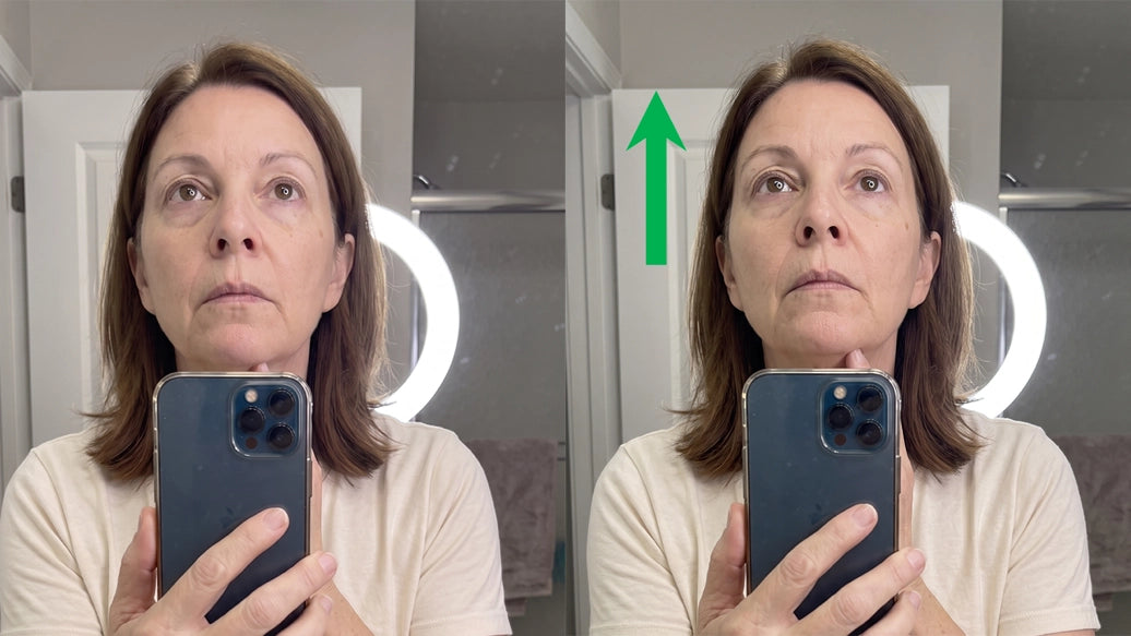 Woman 65+ at a bathroom mirror, tilting her chin to watch the shadow move